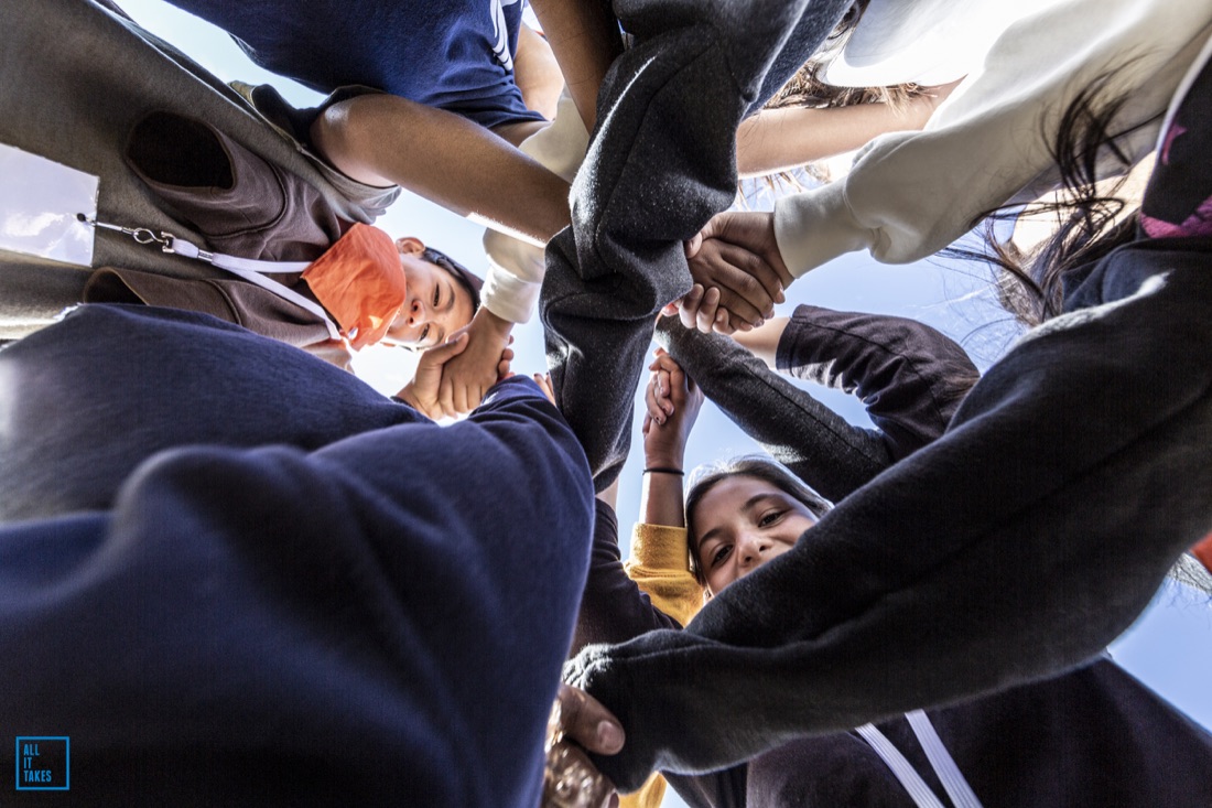 Students holding each other up in a huddle during Lunar Landing